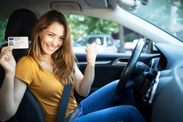 Woman in driver's seat holding an ID