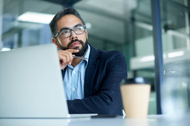 Man thinking in front of a laptop