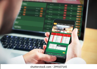 Man holding iphone, sports betting displayed